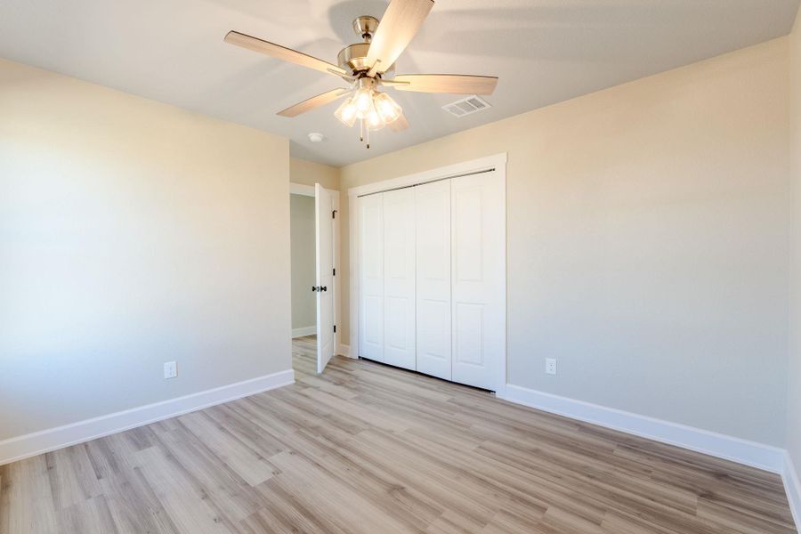 Unfurnished bedroom featuring light wood-type flooring, a ceiling fan, and a closet