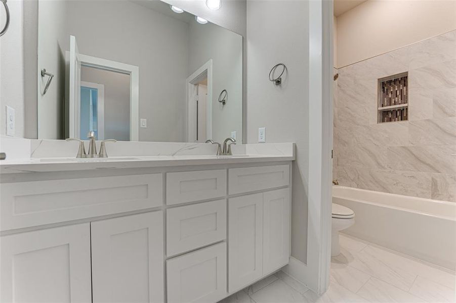 Full bathroom with vanity, toilet, and tiled shower / bath combo