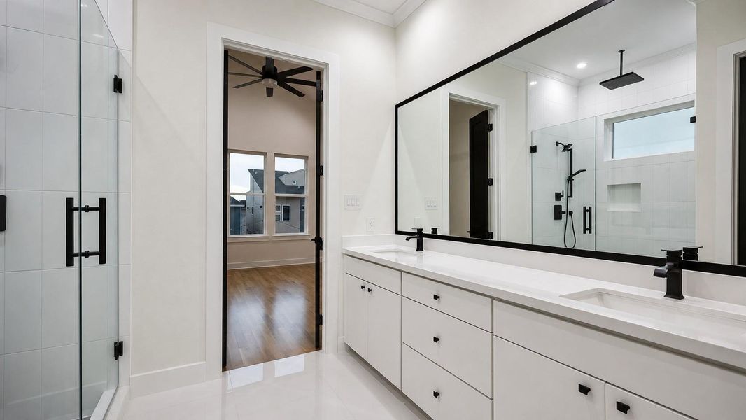 The primary bathroom offers a sleek spa-inspired design with a long double vanity, expansive black-framed mirror, and abundant cabinetry. The oversized glass-enclosed shower features bright white tile, black fixtures, a rainfall showerhead, handheld spray, and a built-in niche. Large-format light flooring and crisp finishes keep the space bright, while the bold black accents create a refined contemporary look. The primary bathroom offers a sleek spa-inspired design with a long double vanity, expansive black-framed mirror, and abundant cabinetry. The oversized glass-enclosed shower features bright white tile, black fixtures, a rainfall showerhead, handheld spray, and a built-in niche. Large-format light flooring and crisp finishes keep the space bright, while the bold black accents create a refined contemporary look.