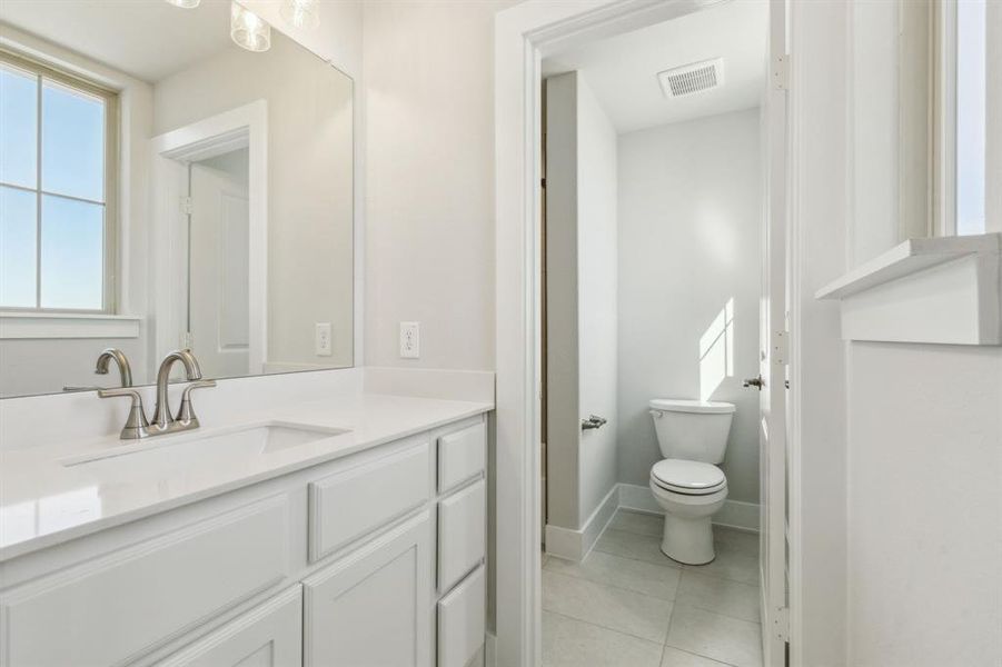 Bathroom featuring tile patterned floors, vanity, and toilet