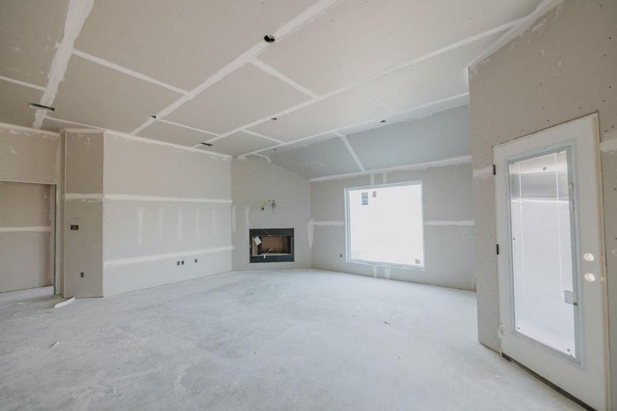Unfurnished living room with a fireplace and concrete flooring Unfurnished living room with a fireplace and concrete flooring