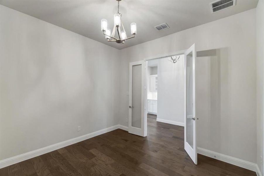 Unfurnished bedroom featuring dark wood-type flooring, a chandelier, and a closet