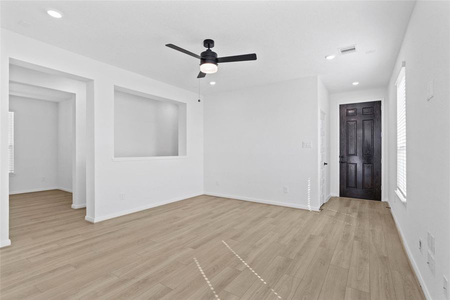 Walking into this gorgeous home, you get a feel of just how bright and open everything is, this space showcases high ceilings, ceiling fan with lighting, recessed lighting, gorgeous Bandera vinyl plank flooring in French Oak, fluid floor plan, custom paint, and plenty of windows allowing in the natural light!