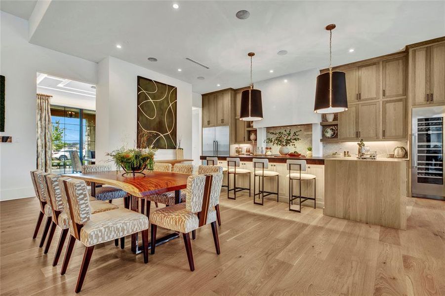 Dining room with wine cooler, light wood finished floors, and recessed lighting Dining room with wine cooler, light wood finished floors, and recessed lighting