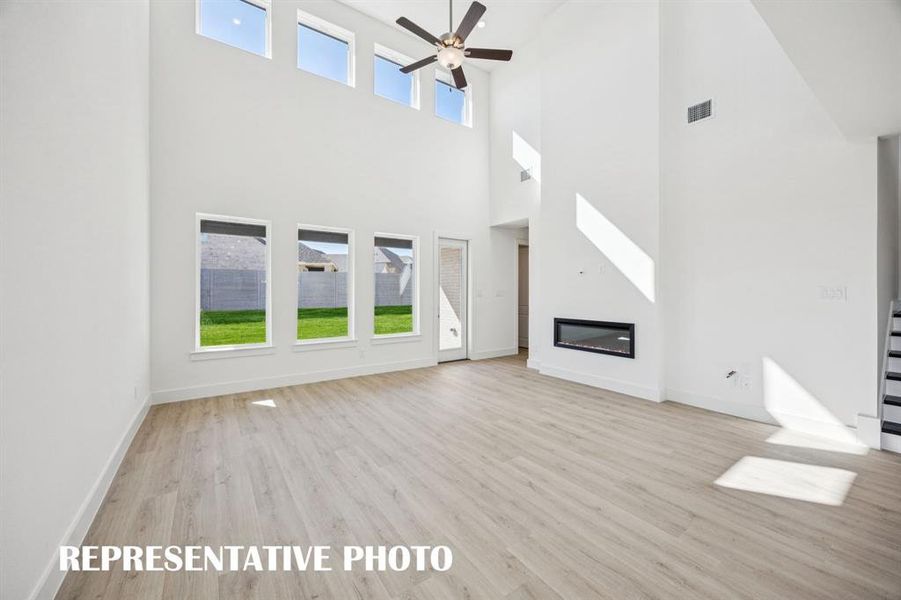 Your new family room is flooded with natural light from a dual stacked wall of windows! REPRESENTATIVE PHOTO
