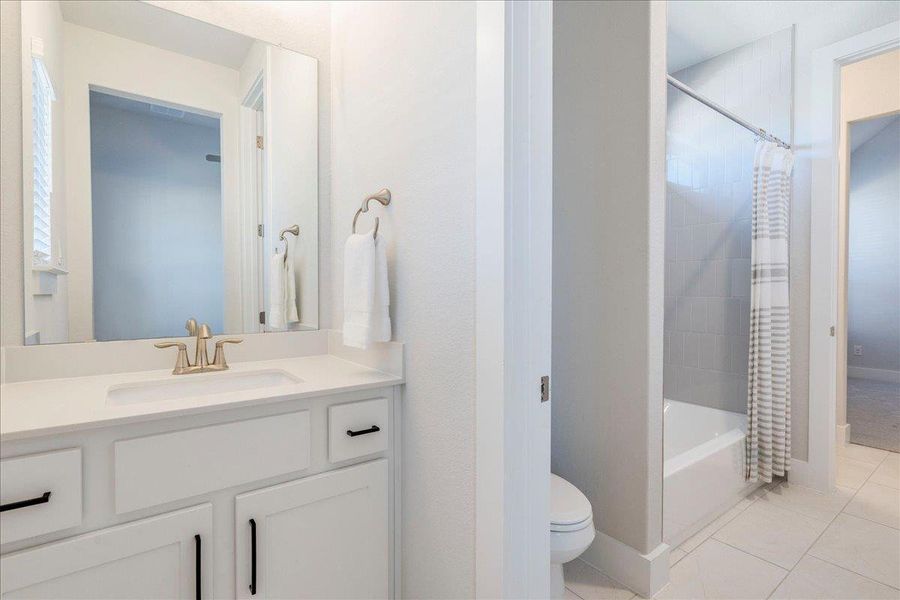 Full bath with vanity, shower / bath combo, and light tile patterned flooring Full bath with vanity, shower / bath combo, and light tile patterned flooring