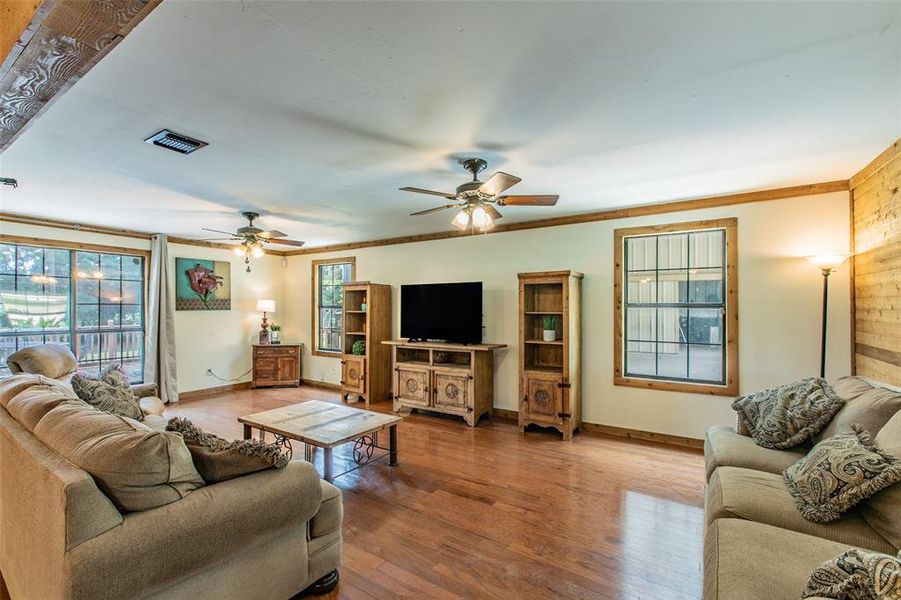 Spacious living area featuring rustic wood accents, abundant natural light, and plenty of room to gather. Spacious living area featuring rustic wood accents, abundant natural light, and plenty of room to gather.