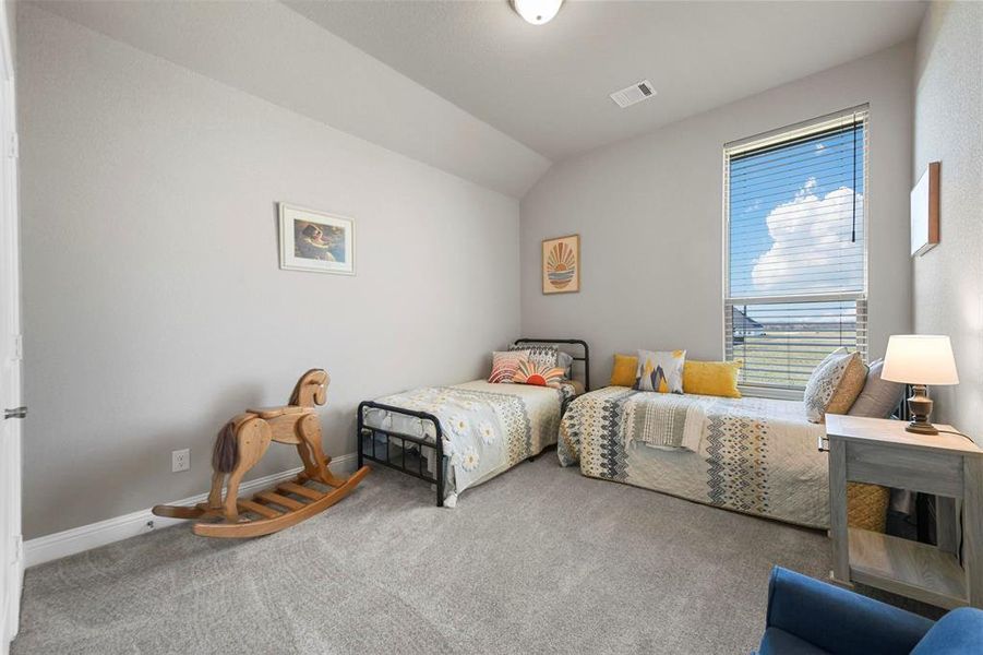 Bedroom with carpet floors and vaulted ceiling