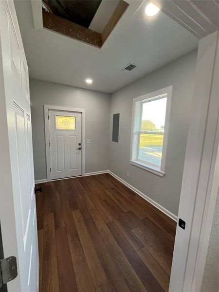 Foyer with dark wood-type flooring, recessed lighting, electric panel, and a tray ceiling Foyer with dark wood-type flooring, recessed lighting, electric panel, and a tray ceiling