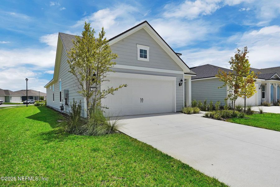 Front exterior of a new home in Summer Bay at Grand Oaks, St. Augustine, FL, highlighting curb appeal (Image 18).