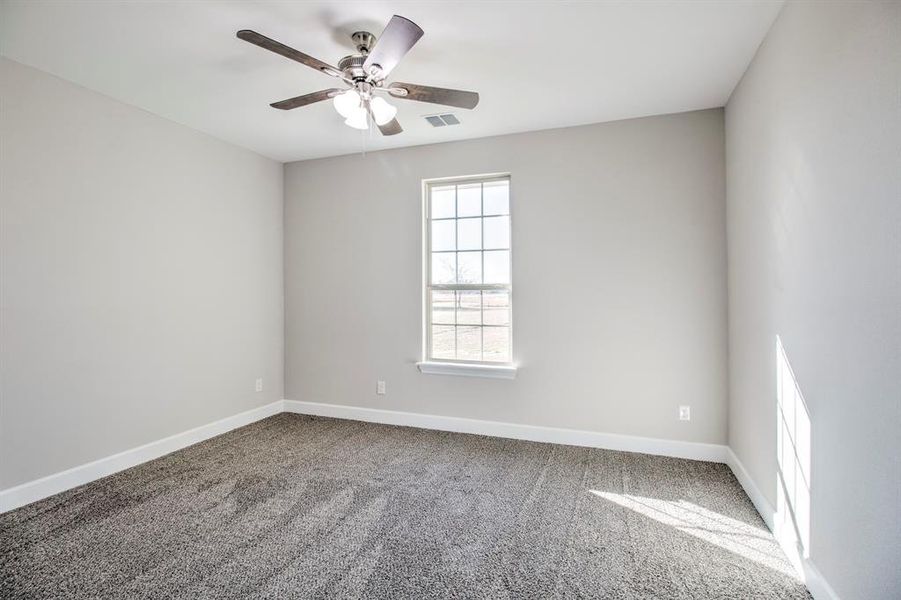 Carpeted empty room with baseboards and ceiling fan