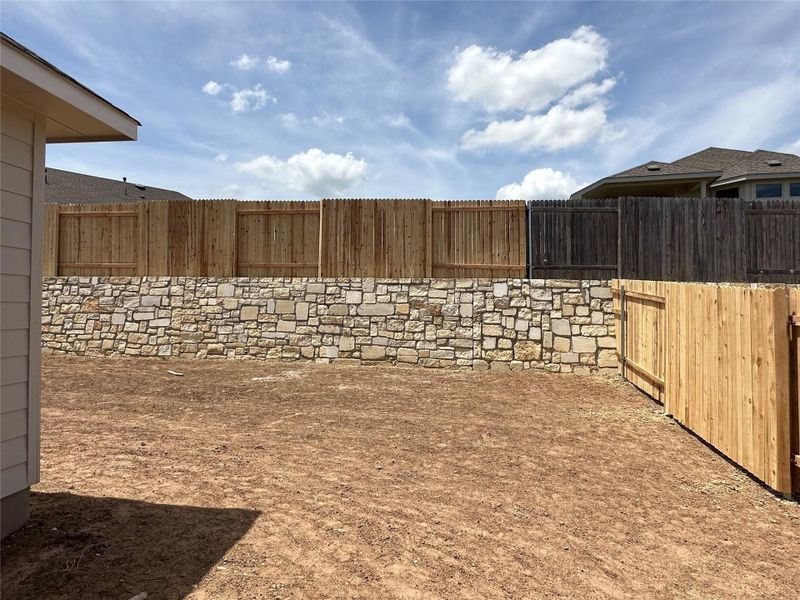 Fenced backyard with a patio