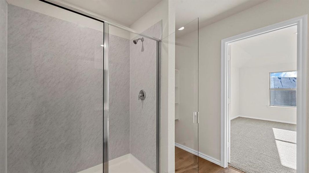 Bathroom with a shower stall and light wood-style flooring