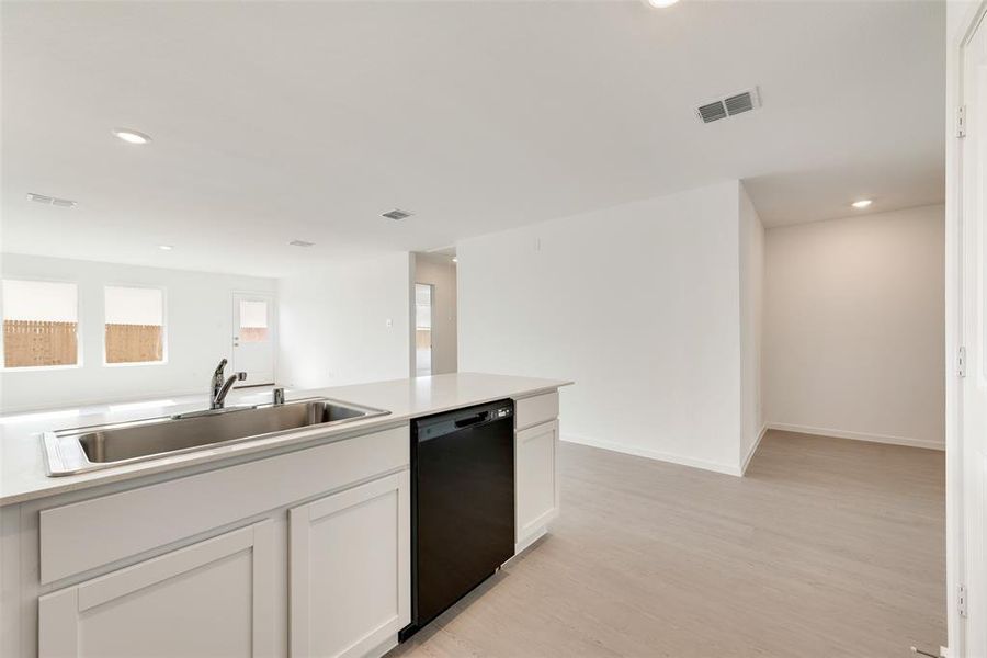 Kitchen with recessed lighting, light wood-style flooring, white cabinetry, and dishwasher