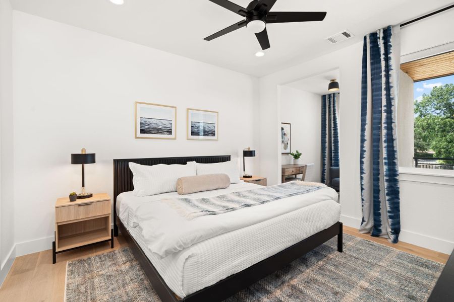 This bedroom is big, bright and modern, offering plenty of natural light and a view of lush greenery.