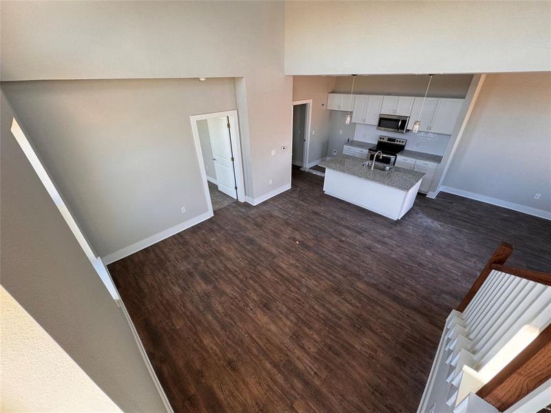 Kitchen with appliances with stainless steel finishes, dark hardwood / wood-style floors, sink, and white cabinets