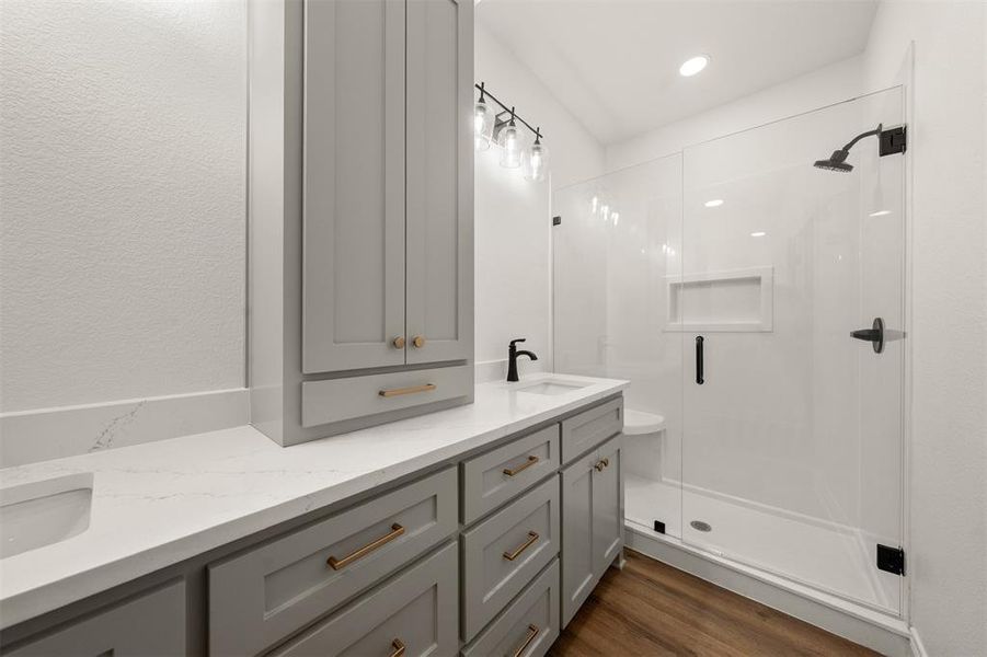 Full bath with double vanity, a shower stall, dark wood-style flooring, and recessed lighting Full bath with double vanity, a shower stall, dark wood-style flooring, and recessed lighting