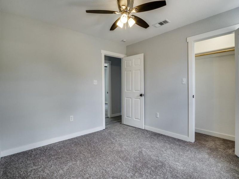 Unfurnished bedroom with carpet, a closet, and ceiling fan Unfurnished bedroom with carpet, a closet, and ceiling fan