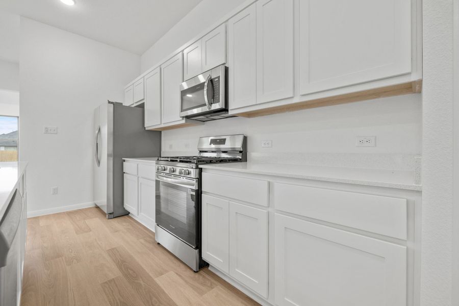 Kitchen in the Quartz home plan by Trophy Signature Homes – REPRESENTATIVE PHOTO
