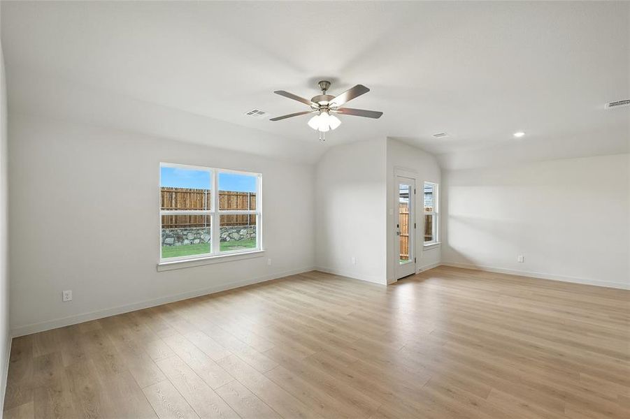 Unfurnished room with light wood-type flooring, a ceiling fan, vaulted ceiling, and recessed lighting Unfurnished room with light wood-type flooring, a ceiling fan, vaulted ceiling, and recessed lighting