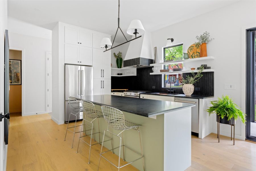 Kitchen featuring open shelves, appliances with stainless steel finishes, dark countertops, a sink, and white cabinetry