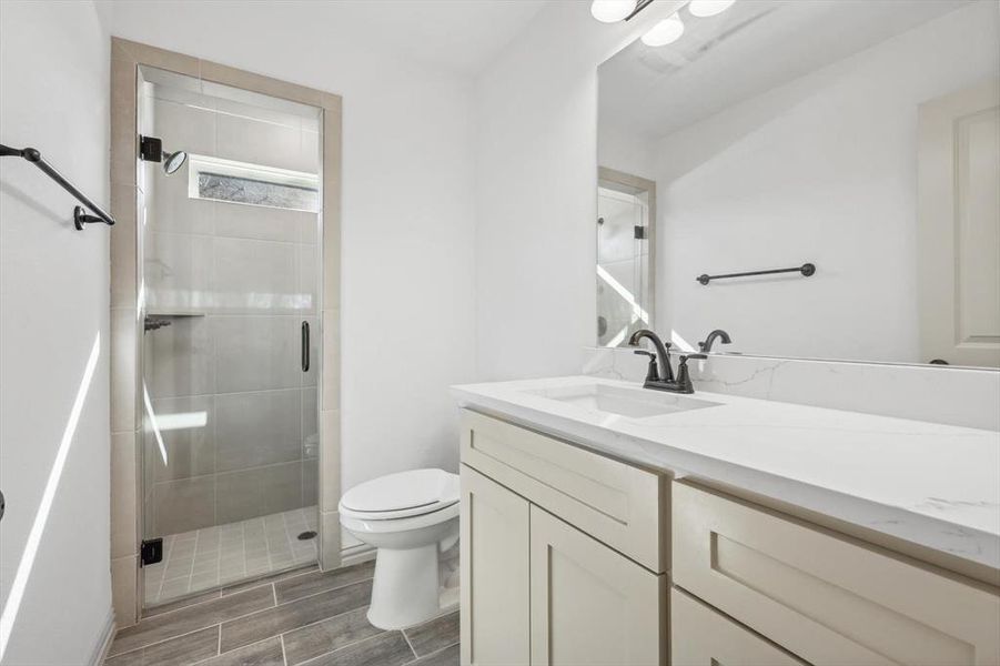 Bathroom with vanity, toilet, and walk in shower