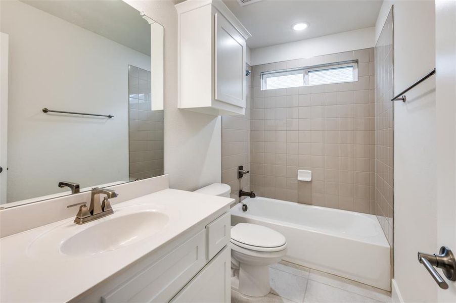 Bathroom featuring toilet, vanity, shower combination, and tile patterned floors Bathroom featuring toilet, vanity, shower combination, and tile patterned floors