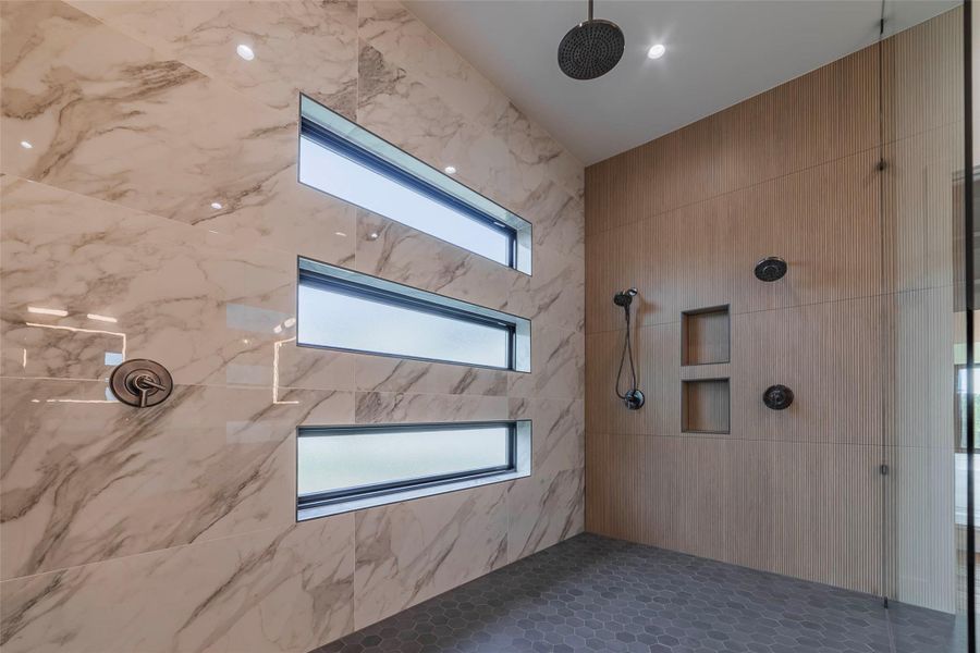 Bathroom with tiled shower and tile walls