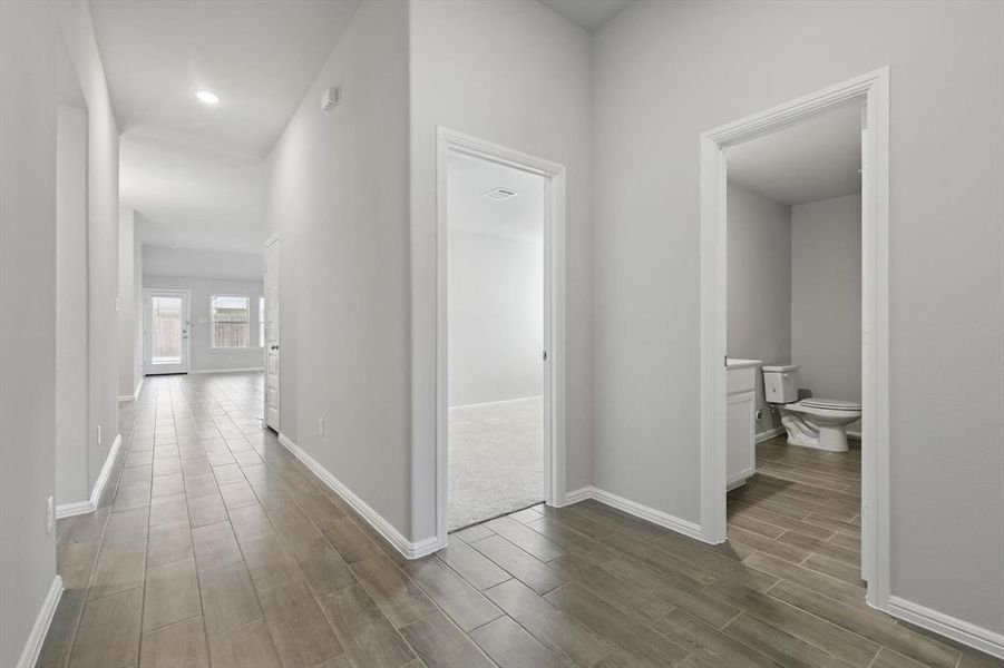 Corridor featuring wood finish floors and recessed lighting Corridor featuring wood finish floors and recessed lighting