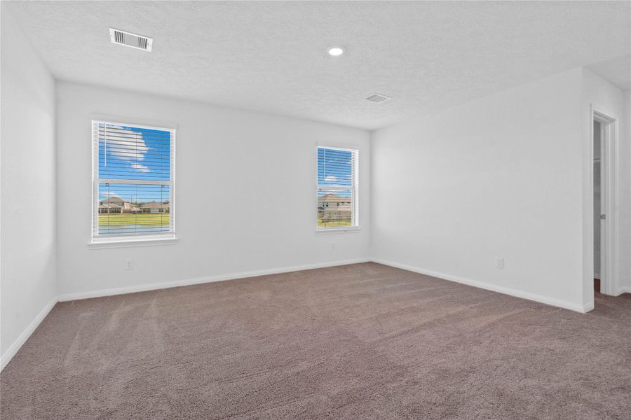 This inviting primary bedroom offers a peaceful retreat with plush carpeting, neutral walls, and abundant natural light streaming through dual windows. The room’s spacious layout and clean design create a serene atmosphere, perfect for relaxation at the end of the day. This inviting primary bedroom offers a peaceful retreat with plush carpeting, neutral walls, and abundant natural light streaming through dual windows. The room’s spacious layout and clean design create a serene atmosphere, perfect for relaxation at the end of the day.