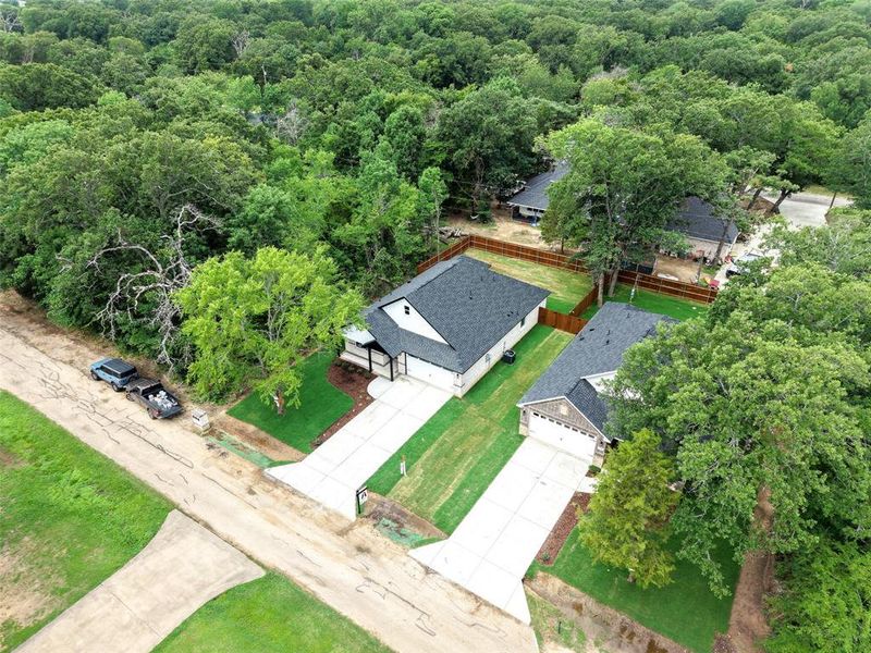 Newly constructed residence featuring a dark shingle roof and white siding Newly constructed residence featuring a dark shingle roof and white siding