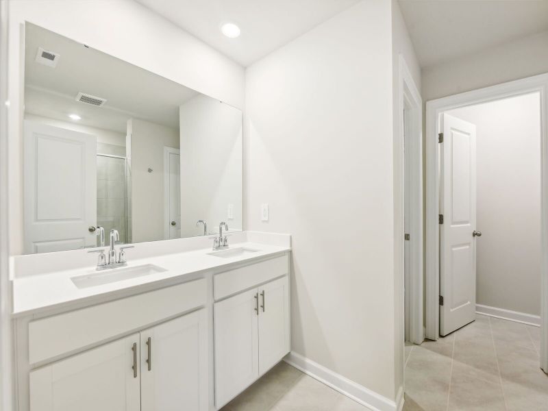 The primary bathroom features a walk-in closet and dual vanities.