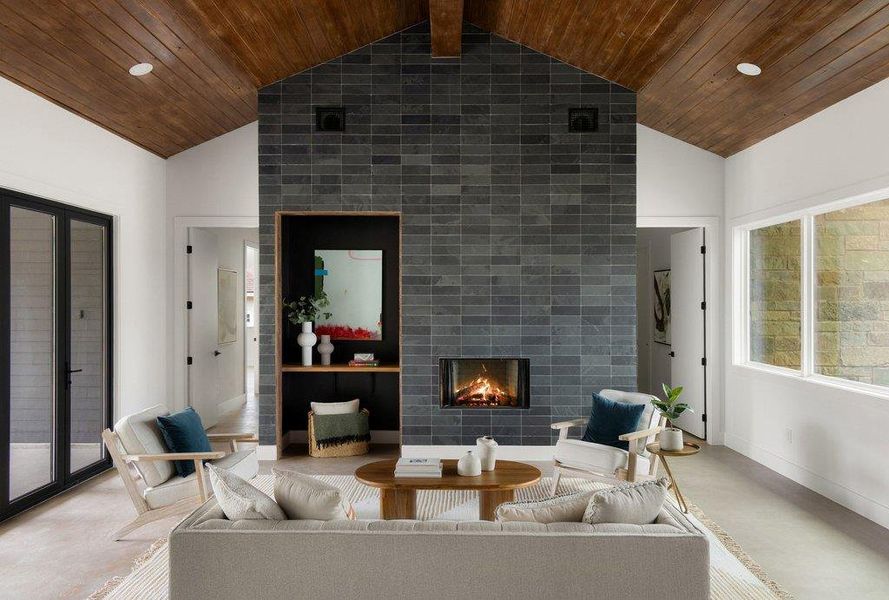 Living area featuring wood ceiling, high vaulted ceiling, recessed lighting, a tiled fireplace, and finished concrete flooring