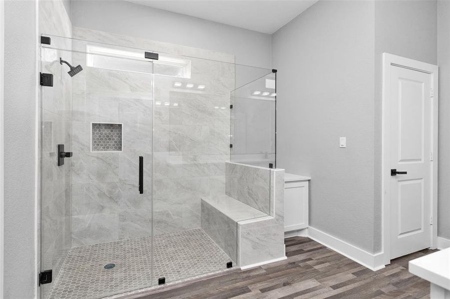 Look at the size of this shower featuring seamless glass, bench, toiletries shelf and  gorgeous tile work.