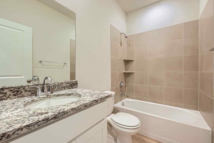 A bathroom with a tub sink and toilet.