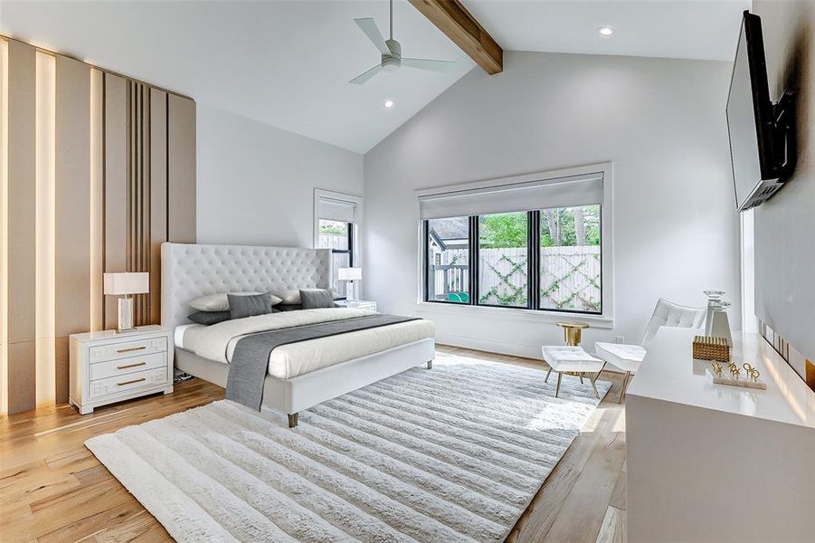 This spacious primary bedroom boasts a modern design with high ceilings and a wood beam accent. It features a plush bed, stylish furniture, custom LED lighting, and large windows that provide abundant natural light. The room is elegantly decorated with a mix of textures and neutral tones, creating a cozy yet sophisticated ambiance.