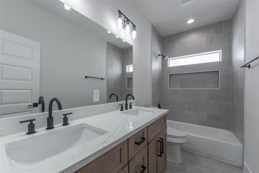 The secondary bath features dual vanities, ample storage, and a tub-shower combo, offering both comfort and functionality. The secondary bath features dual vanities, ample storage, and a tub-shower combo, offering both comfort and functionality.