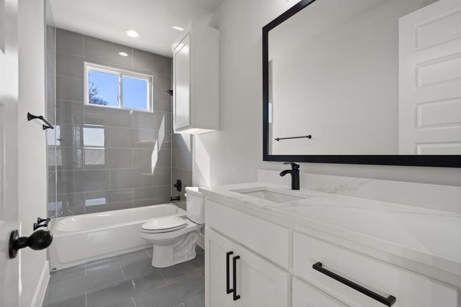 Full bathroom with vanity, toilet, and tiled shower / bath