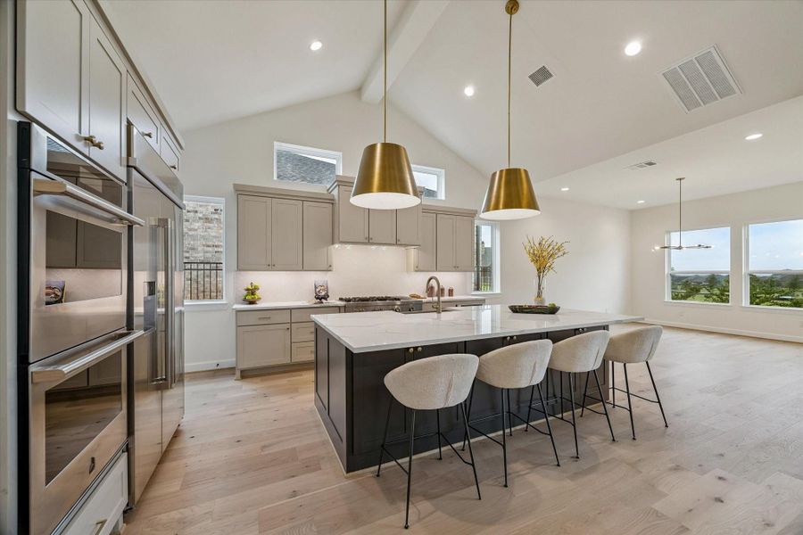 This Kitchen has it all - custom cabinetry, quartz countertops, spacious island with space for seating and storage, under cabinet lighting, high-end appliances.