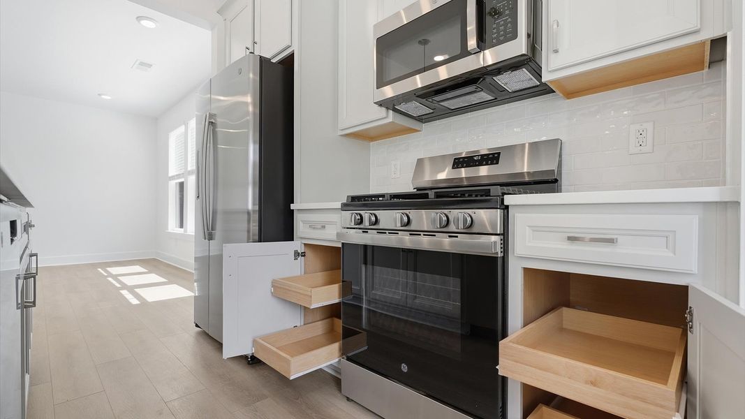 Bright and welcoming kitchen with carefully selected finishes and ample storage located at the Barton Hollow community