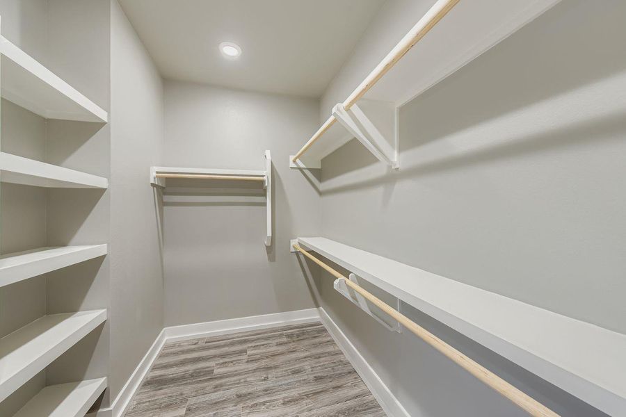 Walk in closet with light wood-style floors