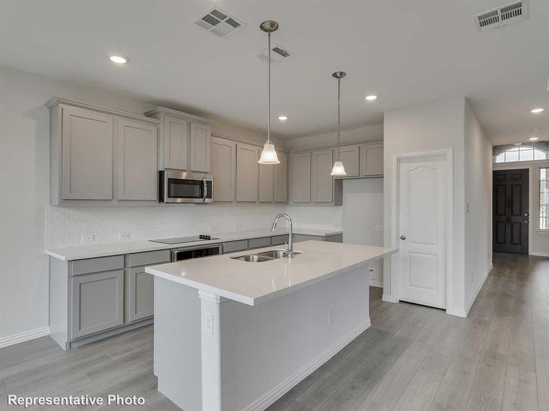 Kitchen featuring gray cabinets, recessed lighting, an island with sink, hanging light fixtures, and stainless steel appliances