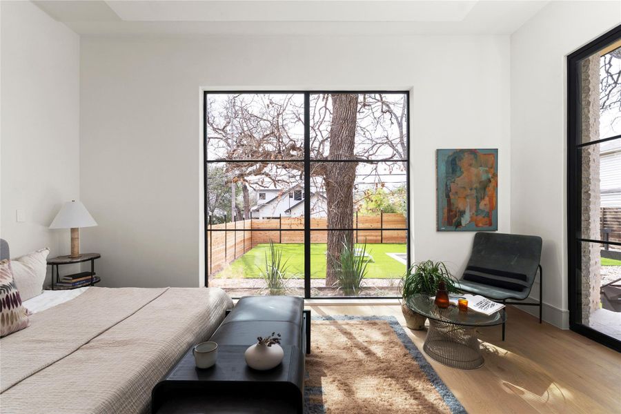 Bedroom with wood finished floors and multiple windows