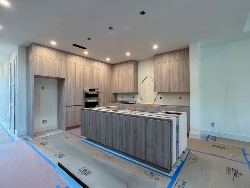 (as of April 8, 2026) the kitchen anchors the first floor living space, quartz countertops to be installed, featuring kitchen aid professional appliances