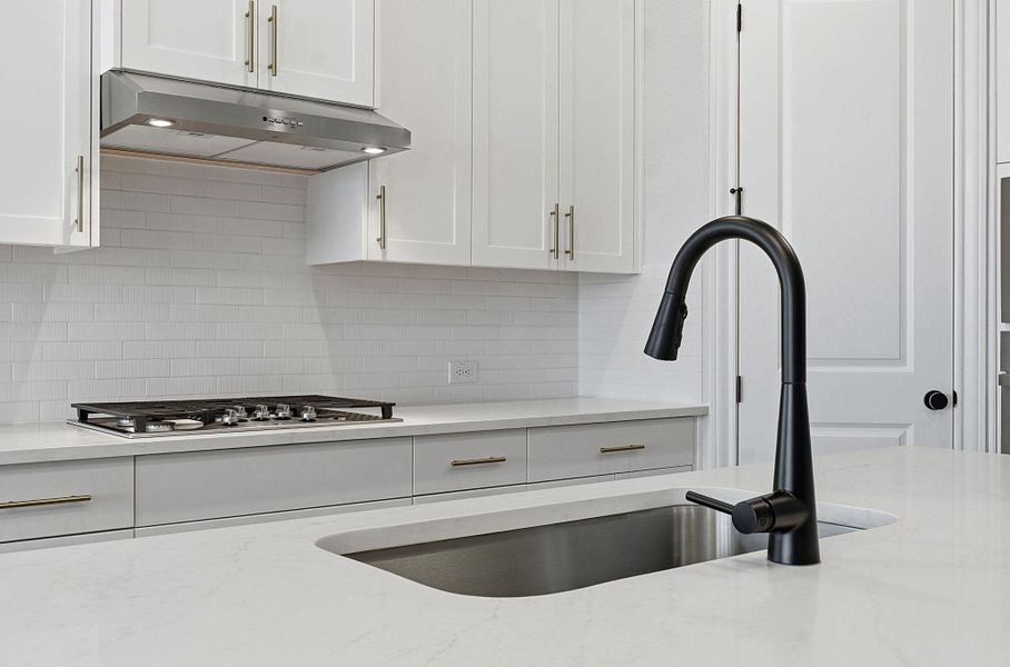Kitchen featuring white cabinetry, light stone countertops, and decorative backsplash
