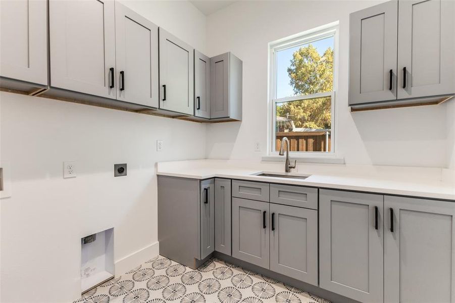 Washroom featuring hookup for an electric dryer, cabinet space, and hookup for a washing machine Washroom featuring hookup for an electric dryer, cabinet space, and hookup for a washing machine