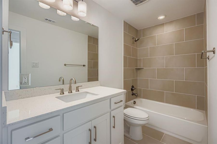 Full bathroom with vanity, light tile patterned floors, and shower / tub combination
