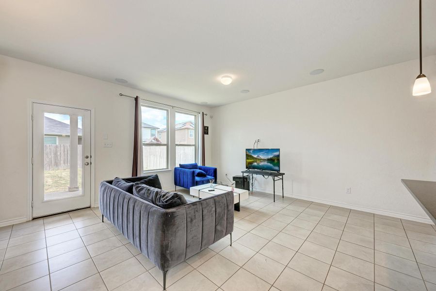 A luminous living space features gleaming tiled floors and a glass-paneled door opening to a private yard.