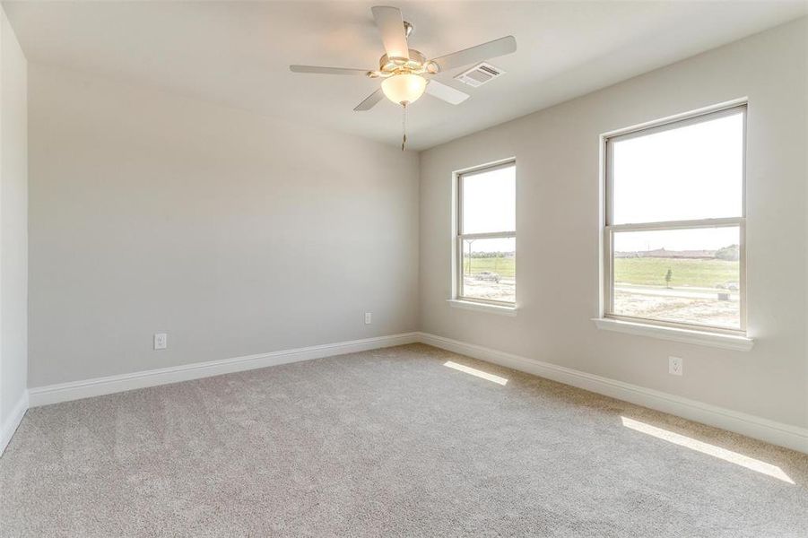 Empty room with light carpet and ceiling fan