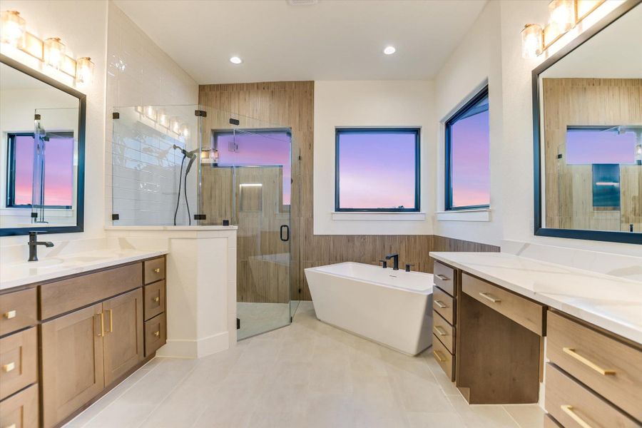 Bathroom with a stall shower, a freestanding bath, two vanities, and recessed lighting